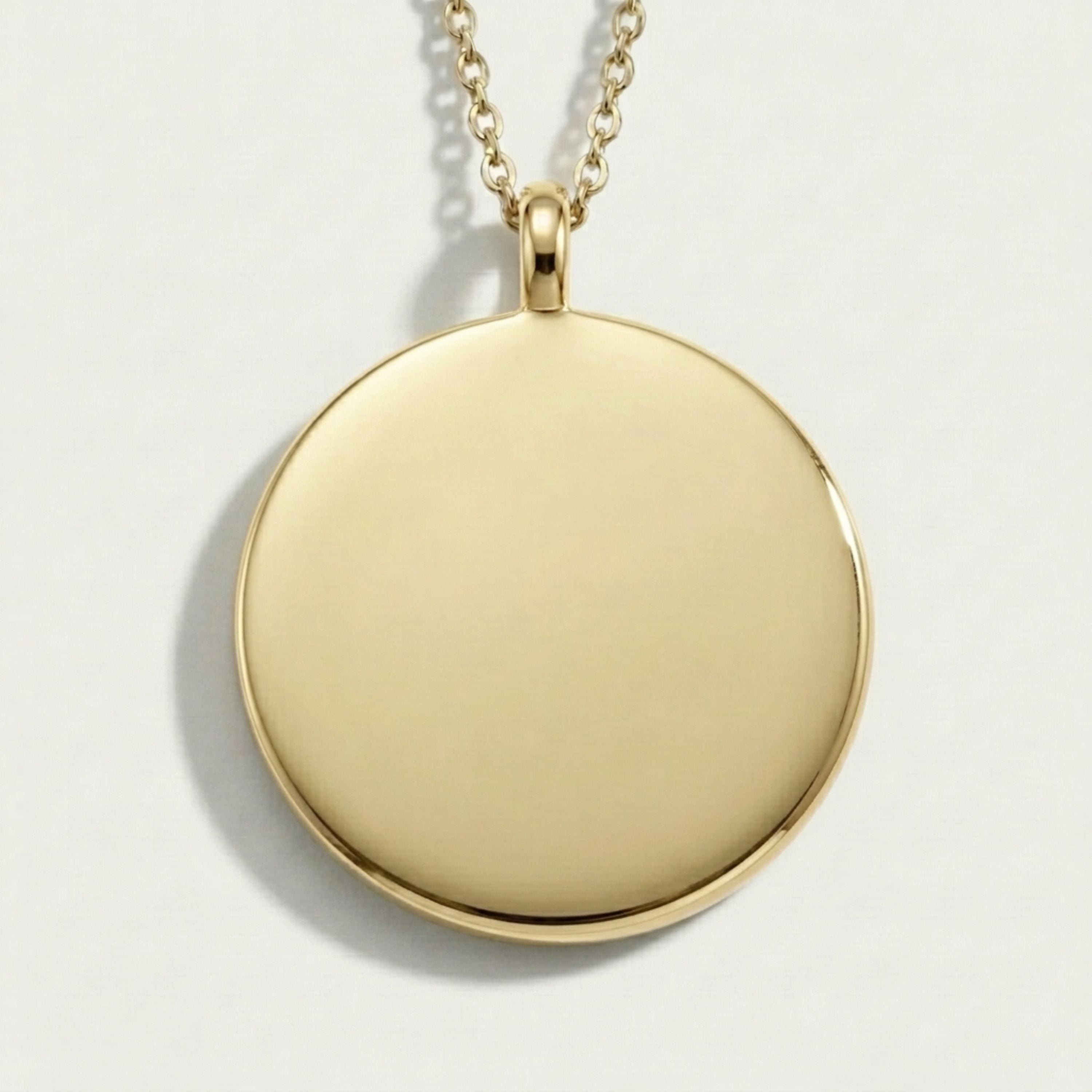 Gold round pendant necklace on a light gray background