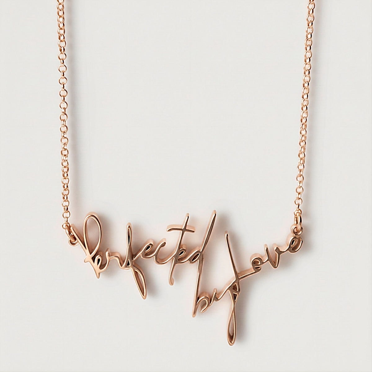 Front view of the Perfected by Love 18K Rose Gold Vermeil Affirmation Necklace featuring its elongated statement pendant.