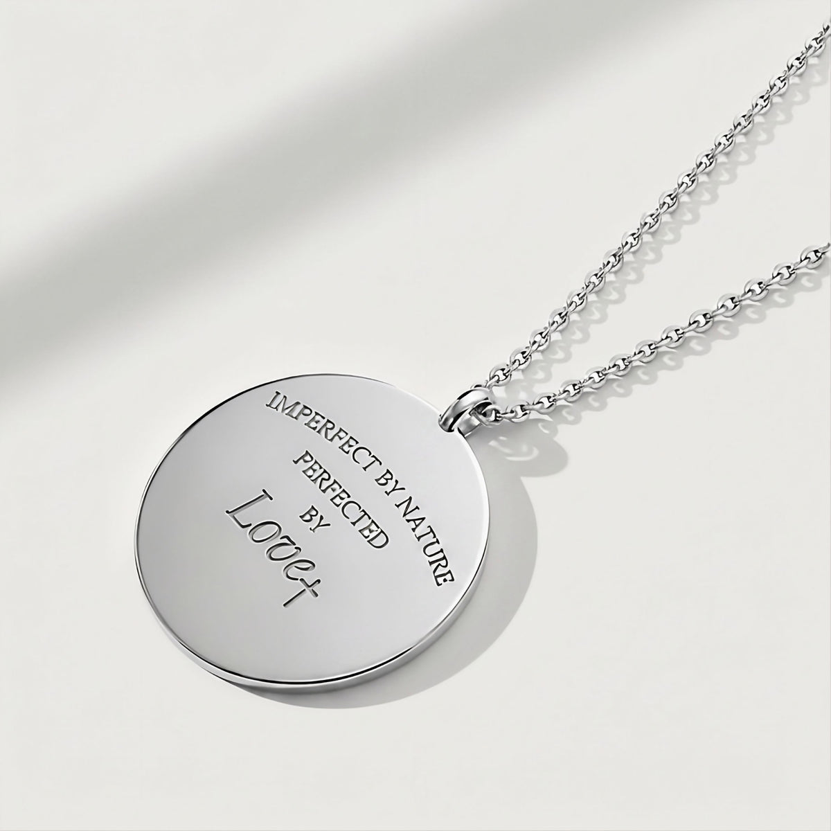 Close-up of the Rachel's Worth Perfected by Love sterling silver coin pendant highlighting its meaningful design.