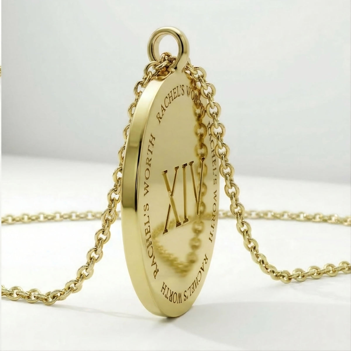 Close-up of the XIV solid 14K gold coin pendant highlighting its polished finish and meaningful design.