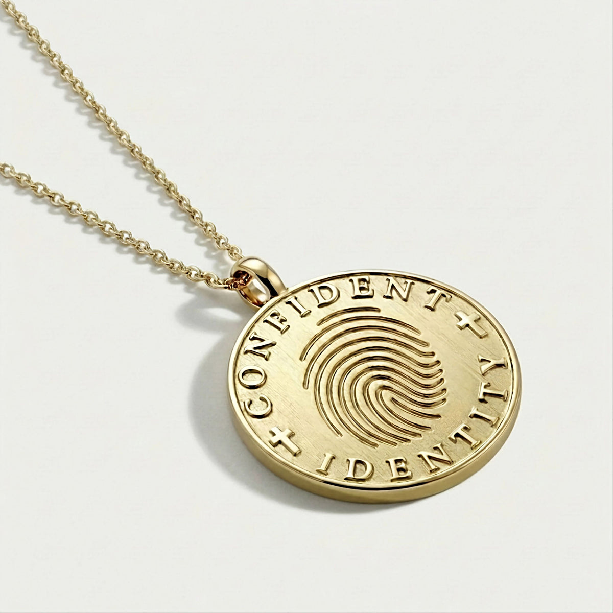 Detailed view of the yellow gold vermeil craftsmanship on the Confident Identity Coin Pendant Necklace.