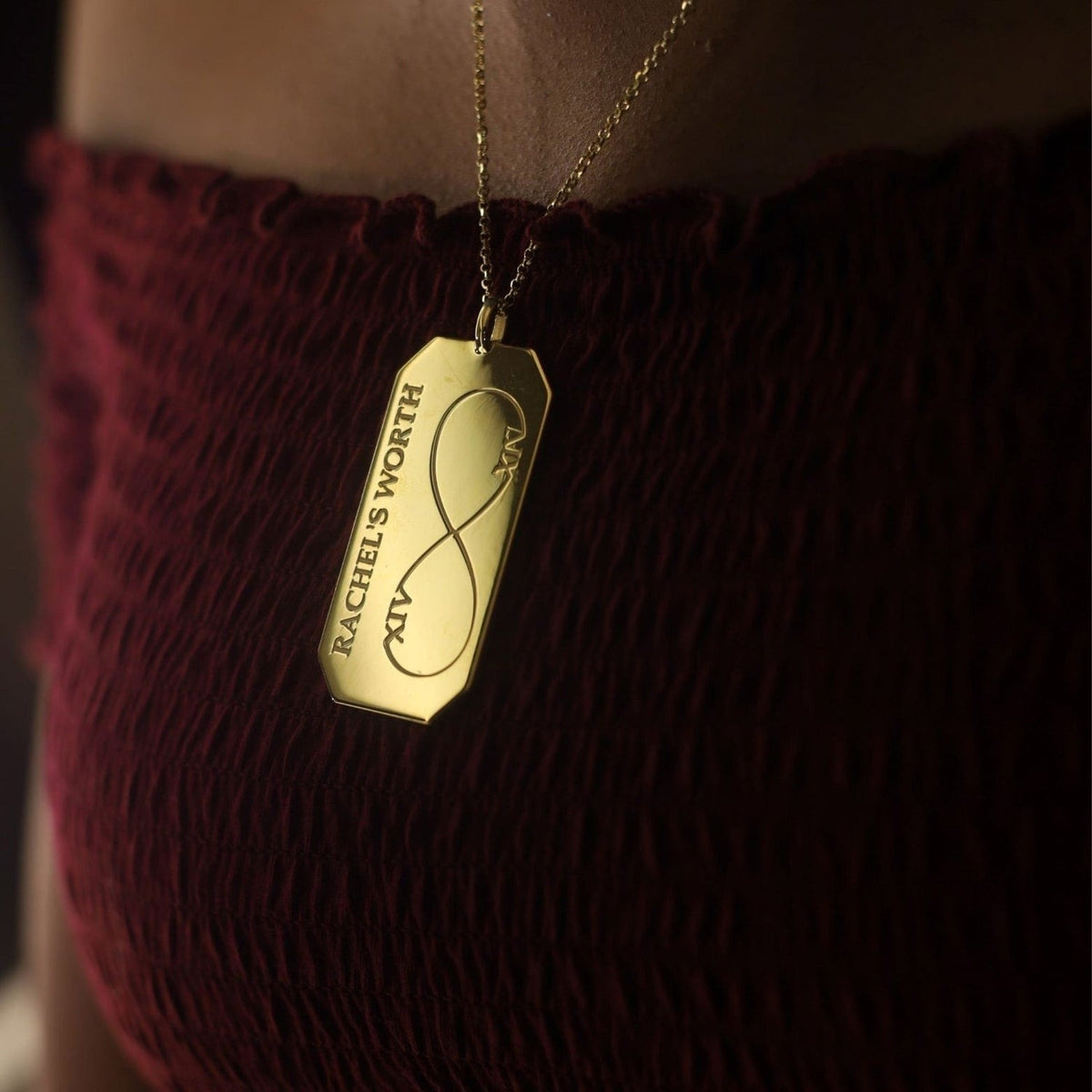 Infinity Solid 14K Gold Pendant Necklace worn at the neckline to show its 2.12-inch pendant and 18-inch chain.