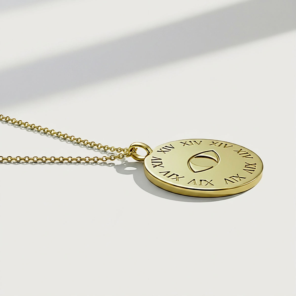 Detailed view of the XIV and eye symbols on the Legacy Solid 14K Gold Coin Pendant Necklace.