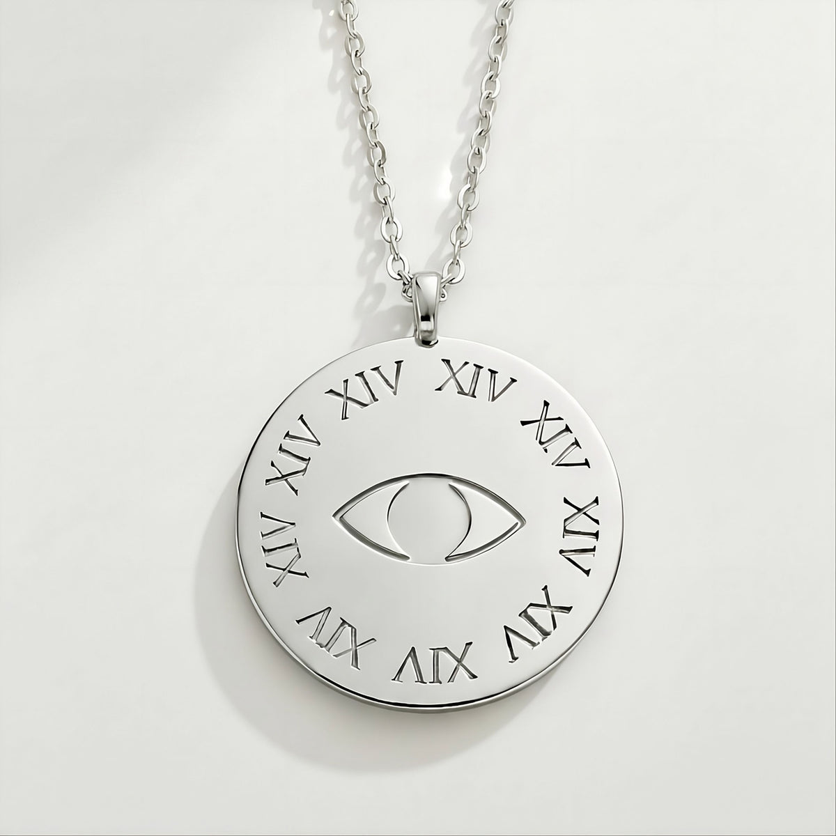 Close-up of the Rachel's Worth Legacy sterling silver coin pendant featuring the XIV and eye design.