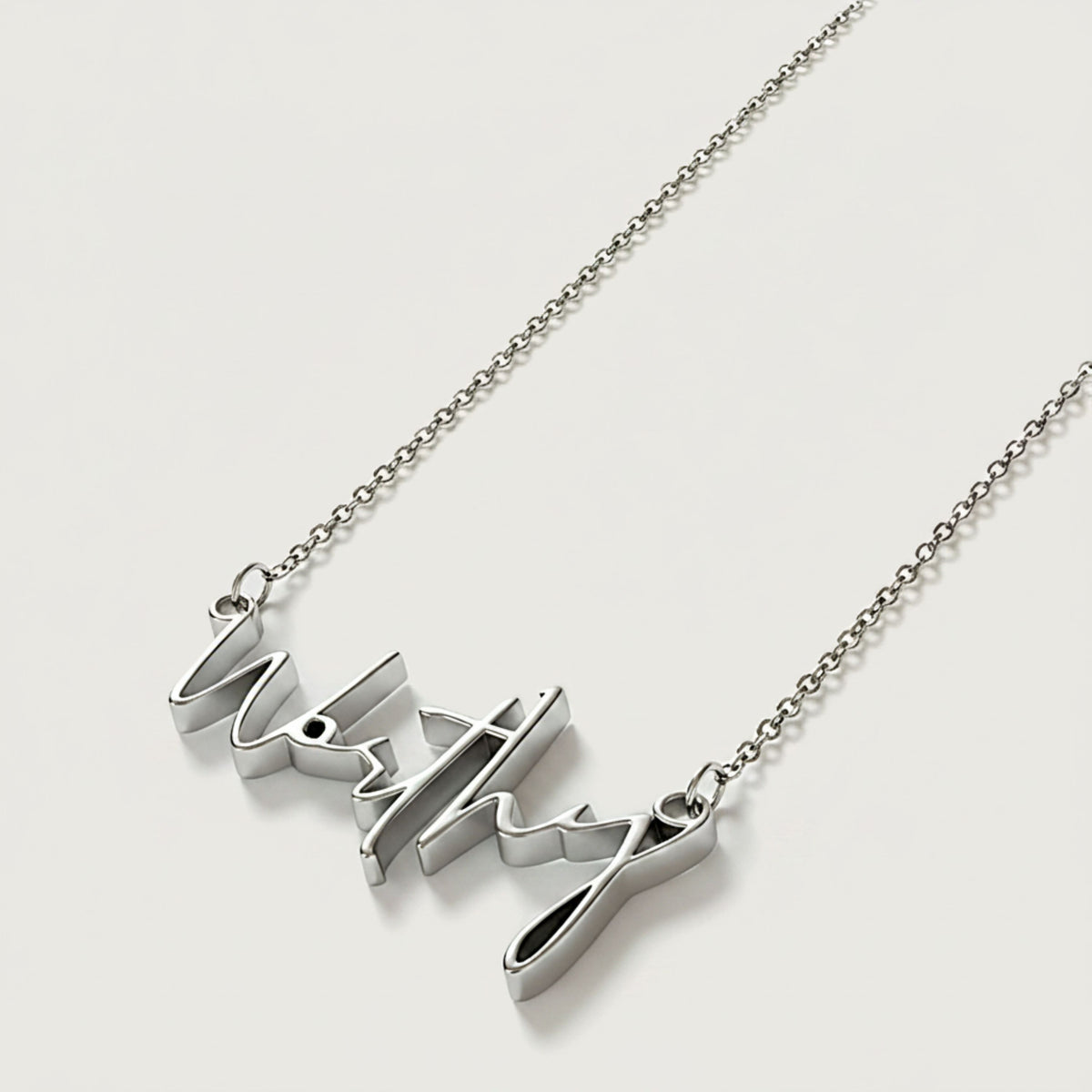 Close-up of the Worthy affirmation pendant highlighting its polished .925 sterling silver finish.