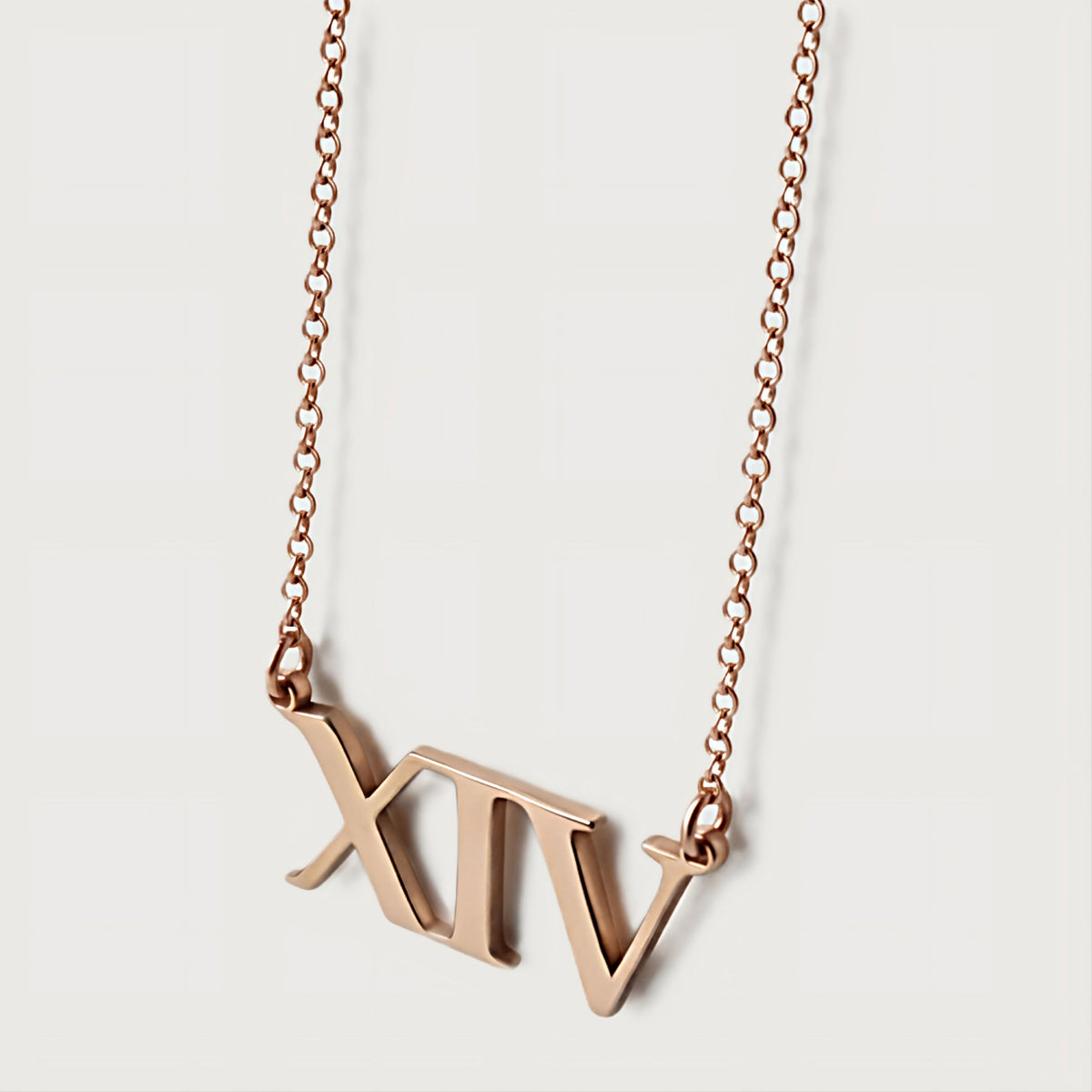 Close-up of the XIV pendant highlighting its warm polished 18K rose gold vermeil finish.